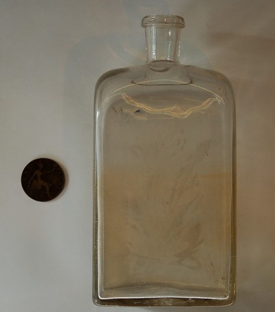 glasflaska från 1800-talet och ett Onepennymynt från 1919. Eget foto 201105