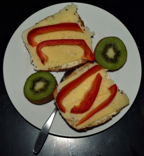 Frukost, grovt bröd med ost och paprika. Kiwi.