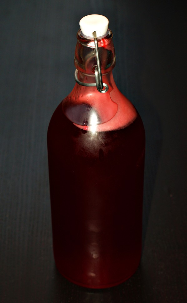Hemmagjord saft av röda vinbär i en snygg flaska