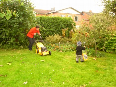 Pappa och son klipper gräset