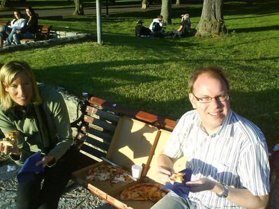Anna och Magnus äter pizza och dricker vin i plastmugg någonstans på Öland