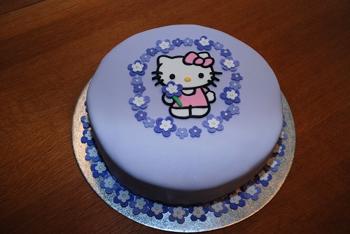 Lila Hello Kitty tårta med lila blommor fylld med hallonmousse och jappfluff